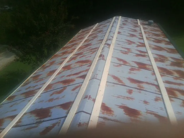 Rusted metal roof panels with new wood purlins before replacement — Storm Damage Roof Repair in Fallon by Roofing Brothers