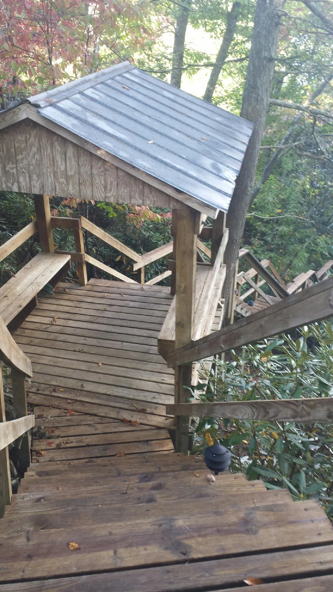 Metal roofed shelter over wooden steps on a wooded walkway — Skylight Repair & Installation work by our crew in Fallon